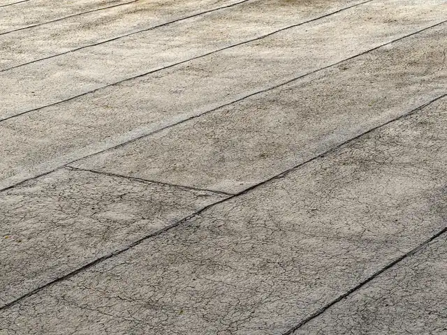 Close-up of a weathered bitumen felt flat roof showing the overlapping seams between sheets