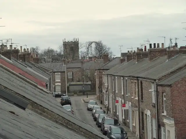 Victorian red-brick terraced houses with Welsh slate roofs and chimney stacks on Kyme Street, York, seen from roof level