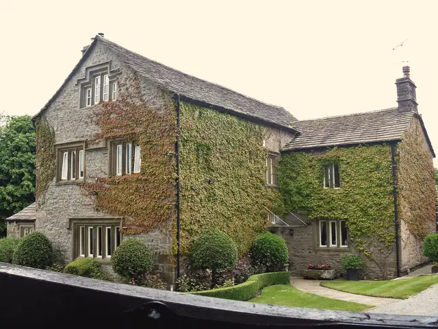 Seventeenth-century stone house with a graded stone slate roof and ivy-covered walls in Gargrave, North Yorkshire