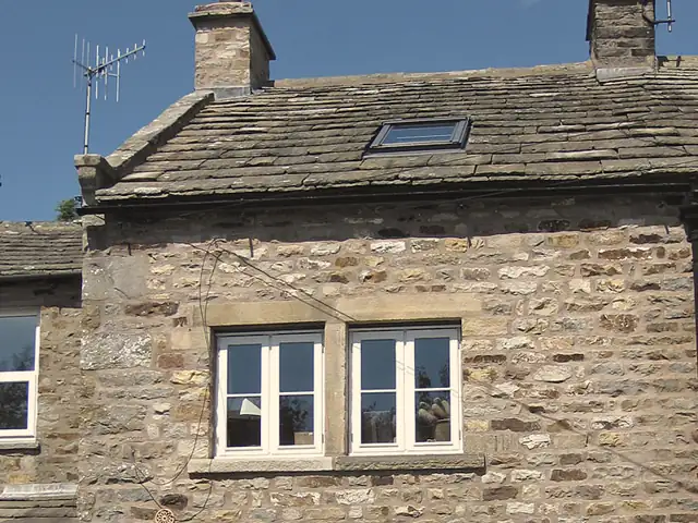 Stone cottage in Reeth with a sandstone slate roof, stone chimneys and a rooflight