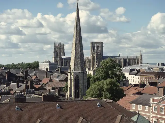 York city-centre rooftops of clay pantiles and slate, with the spire of St Mary's, Castlegate and York Minster behind